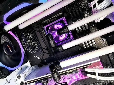 Close-up of a computer motherboard with RGB lighting and cooling components.