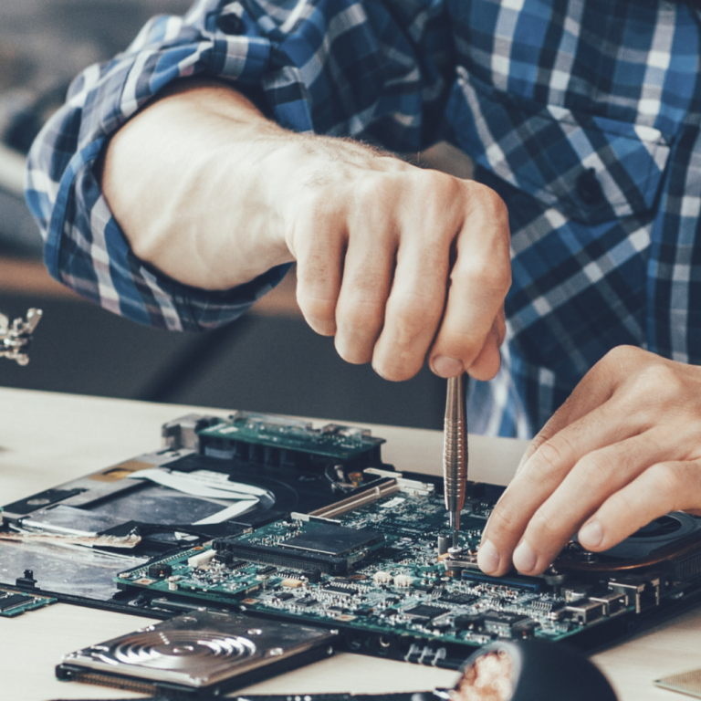 A person repairing a circuit board with a screwdriver.